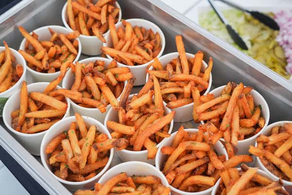 Crispy sweet potato fries served in paper trays, freshly prepared for catering, parties, and waterfront events.