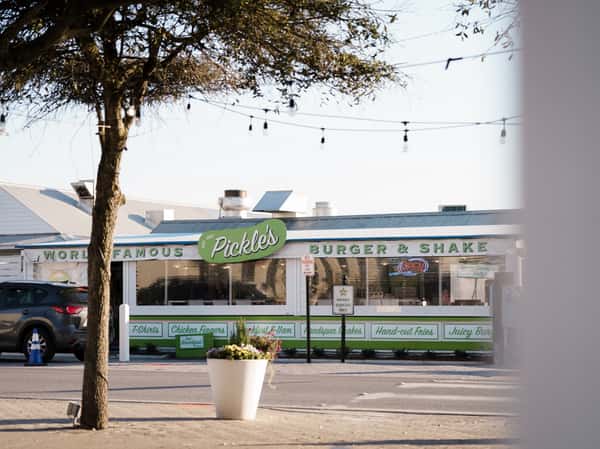 Restaurant exterior with branded signage and outdoor seating in a relaxed coastal setting.