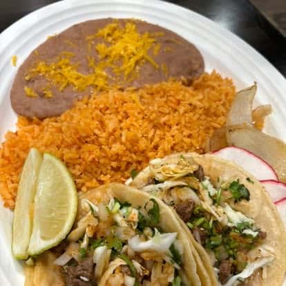 mexican tacos, beans, and rice on a white dish