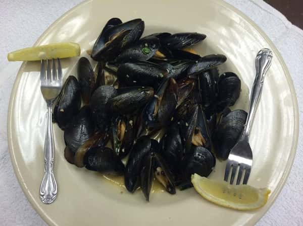 Mussles on a plate with forks and lemon