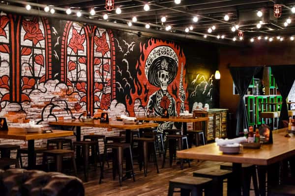 Table and bar style seating with a red and black wall mural