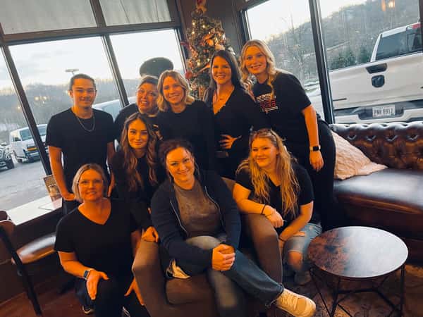 Restaurant staff team posing together inside the dining area, showcasing a friendly and welcoming hospitality environment.
