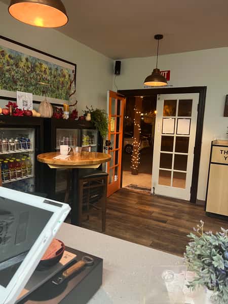A view of the deli's entrance area, highlighting the inviting decor and setup with a cozy table in the foreground
