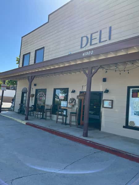 Outdoor seating is visible under a shaded patio, inviting customers to dine outside.