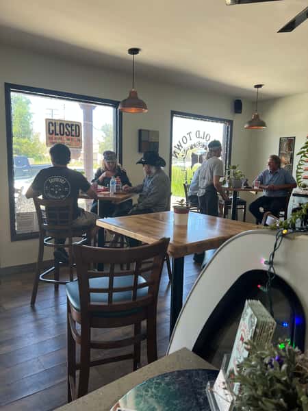 An inside glimpse of The Old Town Deli where patrons are gathered around tables, enjoying their food.