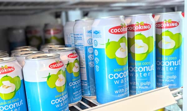 Refreshing Cocoking coconut water with pulp, displayed in chilled cans — hydrating tropical drink popular in Caribbean and Latin cuisines.