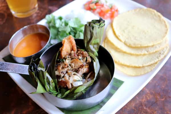 Fresh seafood entrée at Hugo's restaurant with grilled shrimp, vegetables, and vibrant presentation in an upscale dining setting.