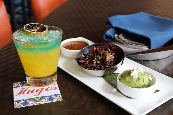 Signature handcrafted cocktails at Hugo's restaurant bar featuring colorful mixed drinks and a refreshing upscale dining experience.