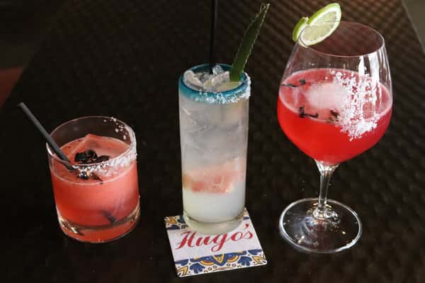 Signature handcrafted cocktails at Hugo's restaurant bar featuring colorful mixed drinks and a refreshing upscale dining experience.