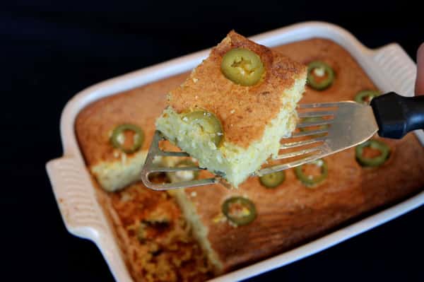 Cheesy jalapeño cornbread casserole baked until golden brown, topped with fresh jalapeño slices and served as a Southern-style side dish.