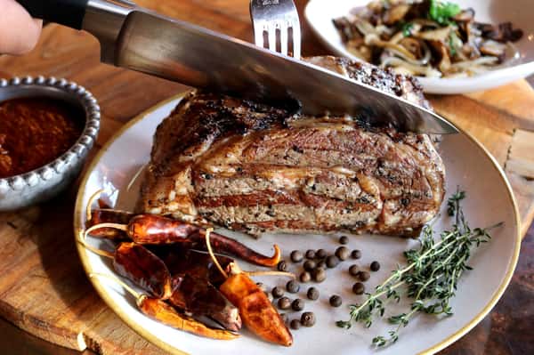 Slow-smoked barbecue ribs glazed with house sauce and served with Southern-inspired sides at Hugo's restaurant.