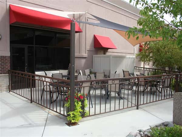 Outdoor dining patio with restaurant entrance in the background