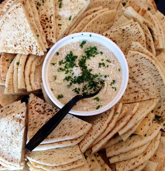 platter of sliced pita bread and a bowl of hummus