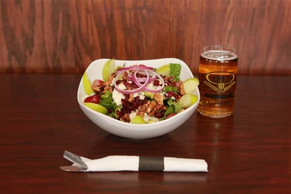 Apple Walnut Salad with a light beer on a wooden table.