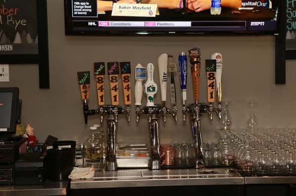 Beer tap behind bar with 12 beer options.
