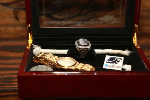 Side view of University of Wisconsin Basketball Champions memorabilia box with a watch and ring inside.
