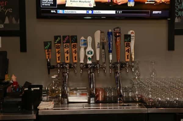 Beer tap behind bar with 12 beer options.