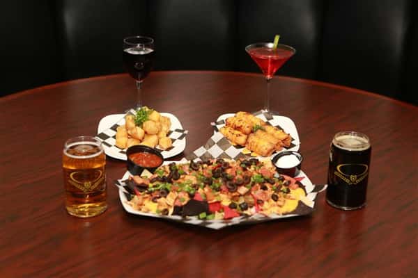 Colby cheese curds, Tatchos, and Bavarian Pretzel Sticks with a glass of red wine, a red martini with a lime slice, a dark beer and a light beer.