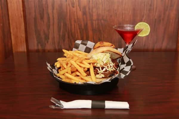 Brew House Specialty Sandwich topped with coleslaw with a side of french fries. Served with a red martini with a lime slice.