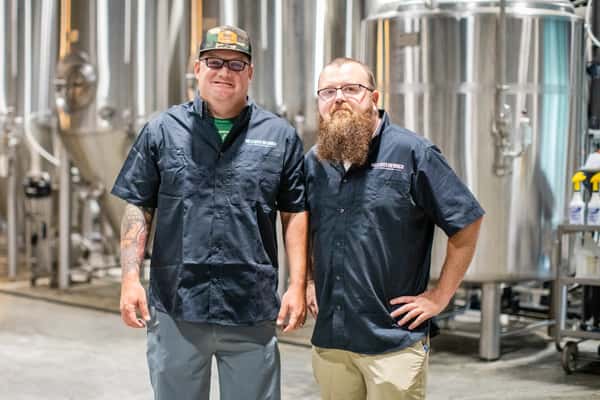 men standing in front of brew machine