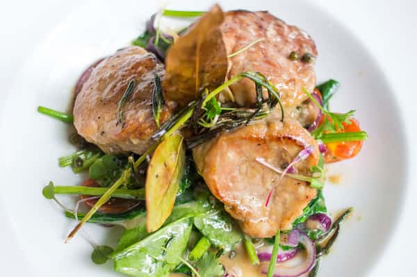 Pan roasted pork tenderloin medallions with green peppercorn and cognac sauce served on inzimino