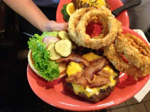 cheeseburger with bacon, pickles, lettuce, onions and a side of onion rings