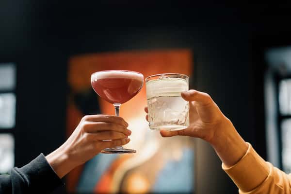 two hands cheers with art backdrop