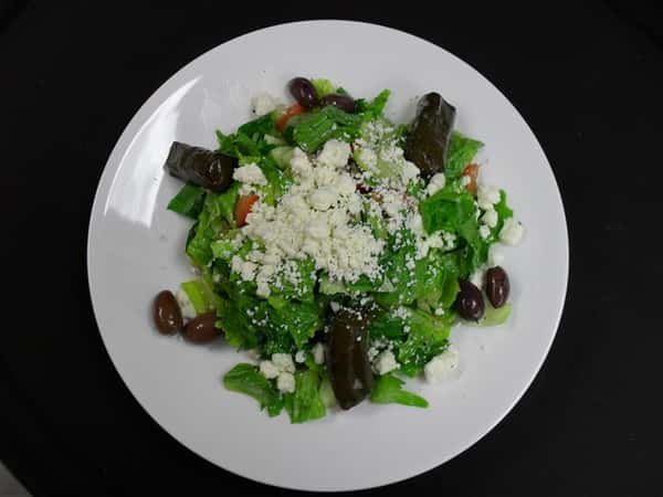 chopped romaine lettuce * tomatoes * kalamata olives * peppers * cucumber * red onion * stuffed grape leaves * feta cheese * house dressing