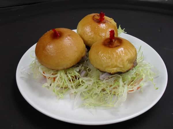 three burgers with shredded lettuce