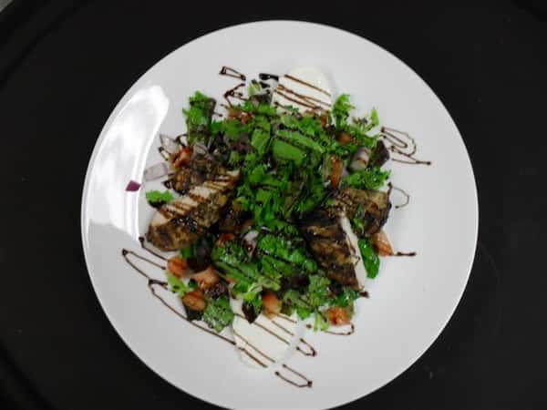 mixed greens with a variety of ingredients and a balsamic drizzle