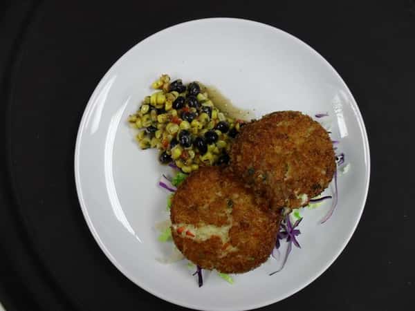 two round balls fried with a side of roasted corn