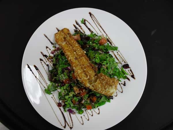salad with mixed greens and a variety of vegetables topped with salmon
