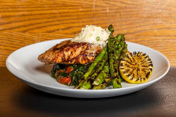 Grilled Faroe Island salmon with asparagus, baked potato, and charred lemon at Gorat's Steak House