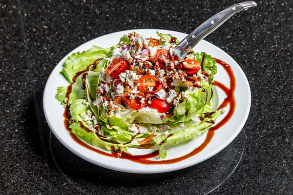 Steakhouse wedge salad with tomatoes, bacon, blue cheese, and balsamic drizzle at Gorat's Steak House