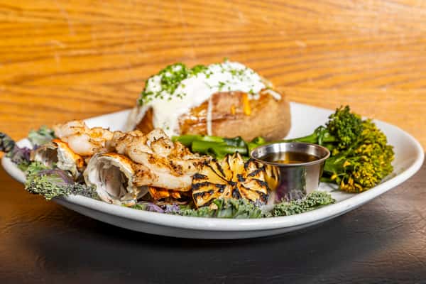 Petite lobster dinner with loaded baked potato, broccolini, grilled lemon, and butter at Gorat's Steak House