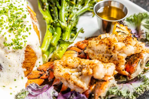 Petite lobster dinner with broccolini, loaded baked potato, grilled lemon, and butter at Gorat's Steak House