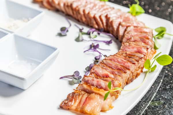 Sliced 12-ounce A5 Wagyu beef with seasonings and accompaniments at Gorat's Steak House