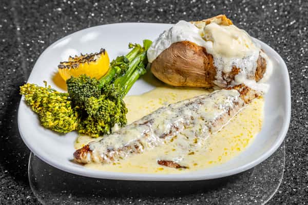 Walleye dinner with creamy sauce, broccolini, baked potato, and grilled lemon at Gorat's Steak House