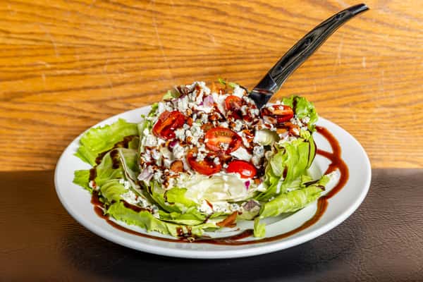 Classic wedge salad with tomatoes, bacon, blue cheese, and balsamic drizzle at Gorat's Steak House