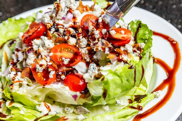 Classic wedge salad with tomatoes, bacon, blue cheese, and balsamic glaze at Gorat's Steak House