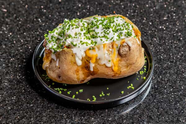 Loaded baked potato topped with sour cream, cheese, and chives at Gorat's Steak House in Omaha