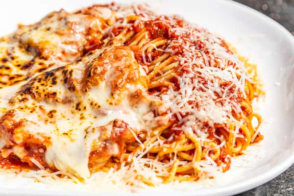 Chicken Parmesan served over pasta with marinara and melted cheese at Gorat's Steak House