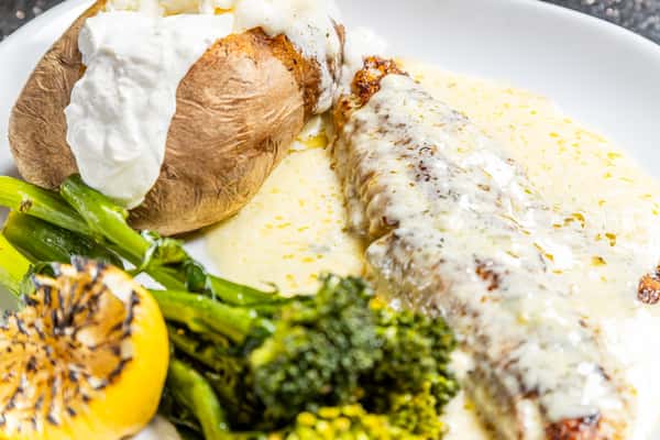 Walleye with creamy sauce, baked potato, broccolini, and grilled lemon at Gorat's Steak House