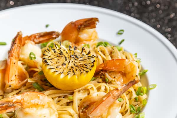 Shrimp scampi with pasta, tomatoes, herbs, Parmesan, and grilled lemon at Gorat's Steak House