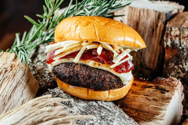 smoked burger on stack of chopped wood