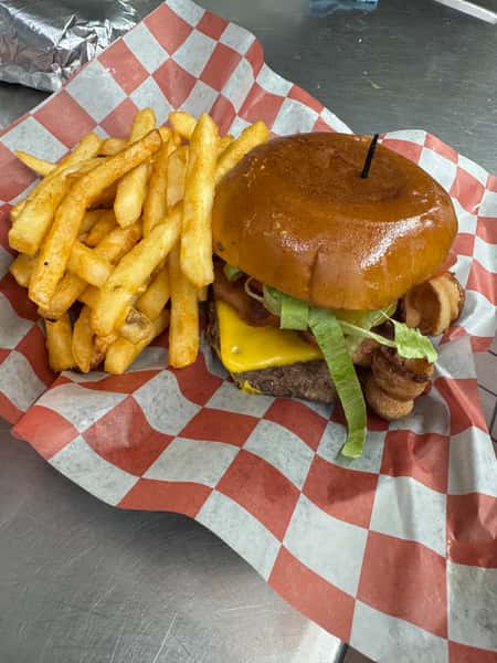 A large cheeseburger with two beef patties, melted cheese, lettuce, and onions, served with crinkle-cut fries in a basket.