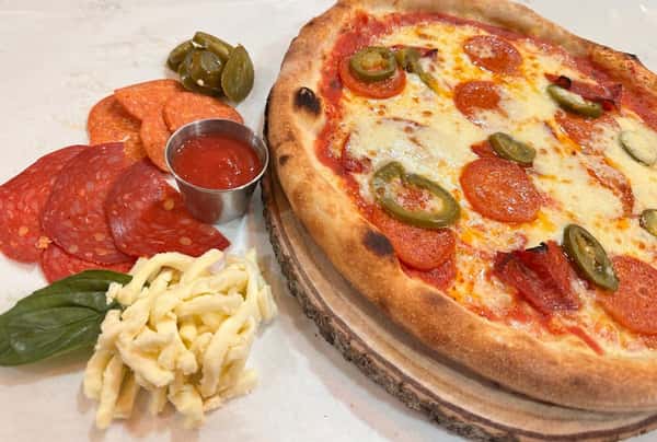 Classic Margherita pizza with fresh mozzarella, tomato sauce, cherry tomatoes, and basil on a rustic wood-fired crust