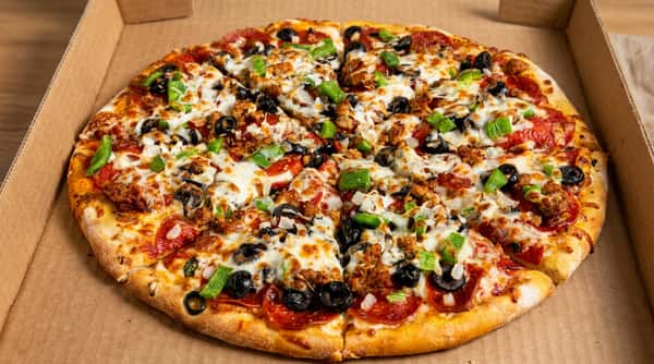 A whole supreme pizza topped with pepperoni, sausage, black olives, green bell peppers, and melted cheese in a cardboard box.