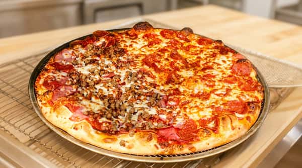 Freshly baked pizza on a metal tray, half pepperoni and half sausage with melted cheese.