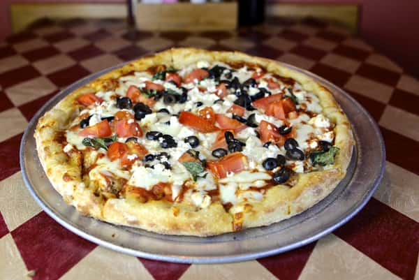 a cheese pizza with onions, tomatoes, and onions
